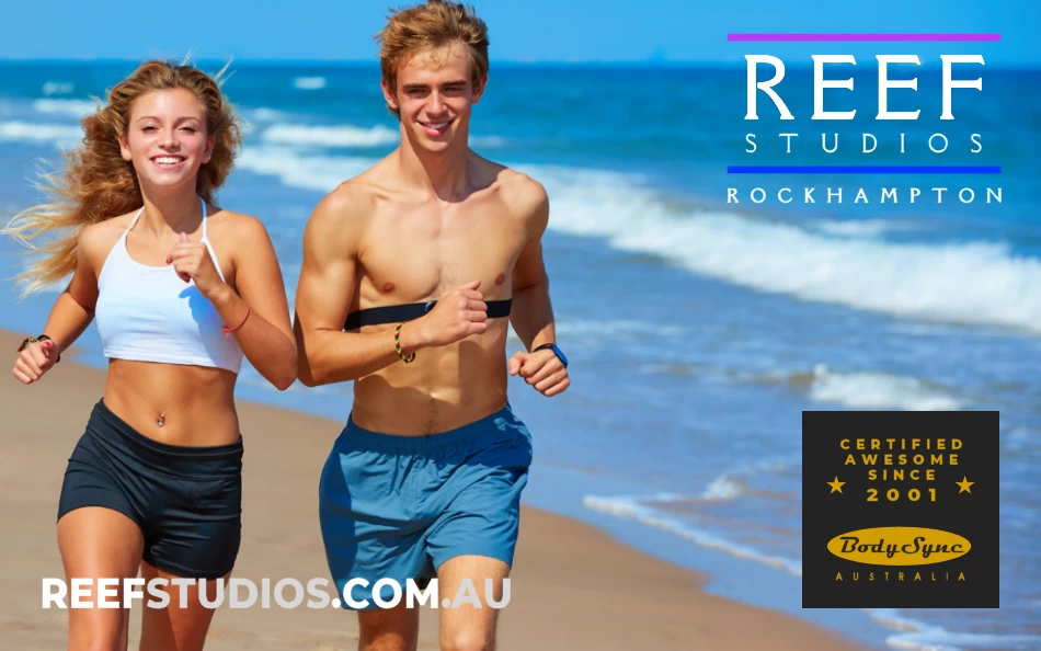 attractive athletic man and woman running along the beach on a sunny day
